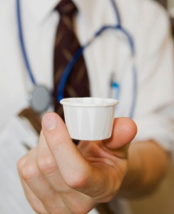 doctor dispensing medicine pills in cup_1